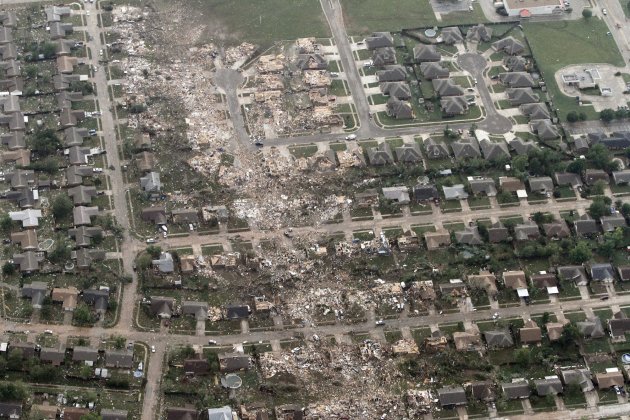 This aerial photo shows the remains of homes hit by a massive tornado in Moore, Okla., Monday May 20, 2013. A tornado roared through the Oklahoma City suburbs Monday, flattening entire neighborhoods, setting buildings on fire and landing a direct blow on an elementary school. (AP Photo/Steve Gooch)