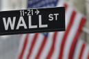 This July 9, 2015 photo shows a Wall Street sign near the New York Stock Exchange in New York. U.S. stocks were mostly lower in early trading Tuesday, July 21, 2015, following weak corporate earnings results from IBM, United Technologies and other big companies. (AP Photo/Seth Wenig)