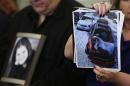 Surviving family member Leo holds a photo of his deceased daughter Kelly as his wife Mary Theresa holds up photos of Kelly's wrecked 2005 Chevrolet Cobalt, before start of Senate subcommittee in Washington