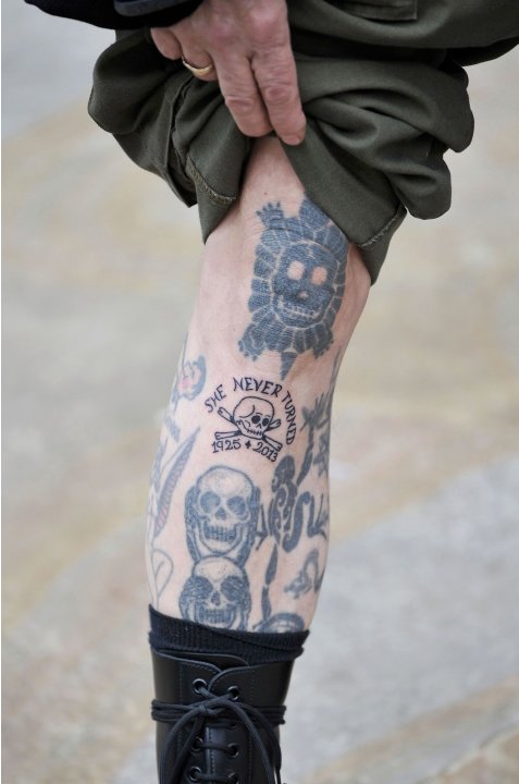 Supporter of former British prime minister Margaret Thatcher displays his tattoos as he joins others by the route of the funeral procession near Downing Street in London