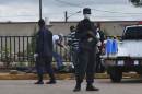 Police stand guard as officers test the body of a man for the Ebola virus, which according to police is standard protocol when bodies are discovered, in Monrovia