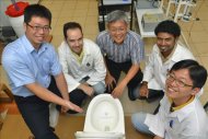Foto cedida por la Universidad singapuresa de Nanyang en la que aparecen los inventores con su inodoro ecológico No-mix Vacuum Toilet. EFE