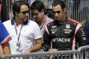 Helio Castroneves, right, of Brazil, talks to crew members as he walks to his car before practice for the IndyCar Firestone Grand Prix of St. Petersburg auto race Saturday, March 28, 2015, in St. Petersburg, Fla. The race takes place on Sunday. (AP Photo/Chris O'Meara)