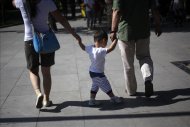 Padres chinos llevan de la mano a su hijo hoy, viernes 15 de junio de 2012, en un parque de Pekín (China). La política de permitir un solo hijo en el país se encuentra bajo escrutinio después de que en internet se publicara el caso de una mujer de 25 años, con siete meses de embarazo, que habría sido forzada por las autoridades a abortar. EFE