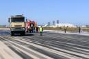 Fire brigade workers clean the runway after an airstrike hit Tripoli's Maitiga airport