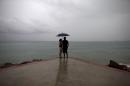 FILE - In this Friday, Oct. 23, 2015, file photo, a couple looks out to sea as rainfall increases with the approach of Hurricane Patricia in Puerto Vallarta, Mexico. Mexico weathered a record eastern Pacific hurricane season with almost no deaths and relatively little damage, given the intensity of this year's storms. According to the U.S. National Oceanic and Atmospheric Administration's 2015 hurricane season report released Tuesday, Dec. 1, 2015, Patricia was "the strongest hurricane on record in the Western Hemisphere" just before it struck a sparsely populated stretch of Mexico's Pacific coast. (AP Photo/Rebecca Blackwell, File)