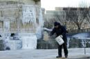Worker spreads sand near an exterior waterfall at the National Museum of the American Indian in Washington