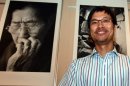 South Korea's Ahn Sehong stands before his photographs of Korean "comfort women"