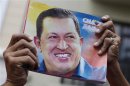 A supporter of Venezuela's President Hugo Chavez holds up a picture of him during the inauguration of the National Assembly in Caracas