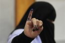 A woman shows her ink-stained finger after casting her vote at a polling station in Cairo