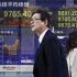 People walk by an electronic stock board of a securities firm in Tokyo, Thursday, Dec. 13, 2012. Asian stock markets rose Thursday with the help of Japan's Nikkei 225, which was propelled higher by a weakening yen. (AP Photo/Koji Sasahara)