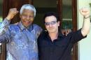 FILE - In this May 25, 2002 file photo, Irish rock star Bono, right, and former South African President Nelson Mandela pose after meeting at Mandela's residence at Houghton in Johannesburg, South Africa. Heroic in his deeds, graceful in his manner, sainted in his image, Nelson Mandela long served as both cause and muse in the entertainment community. From the 1960s, when he was a political prisoner and South Africa was under the laws of apartheid, right up to recent times, when the racist laws of the land had fallen and he was among the world's most admired people, Mandela inspired concerts, songs, poems, fiction and movies. (AP Photo/Juda Ngwenya, File)