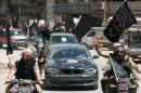 Fighters from Al-Qaeda's Syrian affiliate Al-Nusra Front drive in the northern Syrian city of Aleppo flying Islamist flags as they head to a frontline, on May 26, 2015