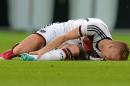 In this picture taken Friday June 6, 2014 German national soccer player Marco Reus lies on the pitch during the friendly soccer match between Germany and Armenia in Mainz Germany. Reus was helped off the pitch after twisting his left ankle while challenging Artur Yedigaryan for the ball. Reus immediately dropped to the grass and appeared in considerable pain. Team doctor Hans-Wilhelm Mueller-Wohlfahrt shook his head as he assisted the Borussia Dortmund player off the pitch. Reus was taken to the hospital to determine the full extent of the injury. AP Photo/dpa,Thomas Eisenhuth)