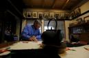 Hashimoto speaks in front of ancestral portraits during an interview with Reuters at his home in Naraha