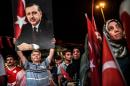 A man holds up a photo of Turkey's President Recep Tayyip Erdogan during a pro-Erdogan rally in Taksim square in Istanbul on July 22, 2016