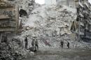 Members of the Syrian Civil Defence search for victims amid the rubble of a destroyed building following reported air strikes in Aleppo, on October 17, 2016