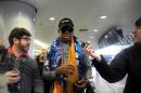 El exjugador de baloncesto Dennis Rodman (c) habla con unos periodistas el 19 de diciembre de 2013 en el aeropuerto de Pekín