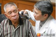 台灣皮膚科醫學會理事長楊志勛（右）利用「皮膚鏡」替70歲的張老先生（左）檢查皮膚癌。（攝影／張世傑）