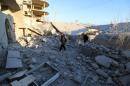 Residents inspect damage after airstrikes by pro-Syrian government forces in Anadan city