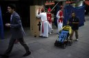 Spaniards dressed up like Bishops for a stag party play the role of a confessor in downtown Madrid, Saturday June 9 2012. Spain will ask for a bank bailout from the eurozone, becoming the fourth and largest country to seek help since the single currency bloc's debt crisis erupted.(AP Photo/Daniel Ochoa de Olza)