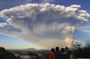Children watch the Calbuco volcano erupt, from Puerto Varas, Chile, Wednesday, April 22, 2015. The volcano erupted billowing a huge ash cloud over a sparsely populated, mountainous area in southern Chile. Authorities ordered the evacuation of the inhabitants of the nearby town of Ensenada, along with residents of two smaller communities. (AP Photo/Carlos F. Gutierrez) - CHILE OUT - NO USAR EN PUBLICACIONES O WEBSITES EN CHILE