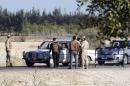 Egyptian security personnel check cars at a checkpoint near the site, where separate attacks on security forces in North Sinai on Thursday killed 30 people, in Arish, North Sinai