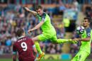 Liverpool's James Milner jumps for the ball as Burnley's Sam Vokes and Liverpool's Dejan Lovren look on during their English Premier League match, at Turf Moor in Burnley, on August 20, 2016