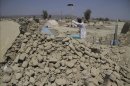 Un hombre intenta este viernes quitar los escombros de su casa tras el terremoto en Awaran (Pakistán). EFE