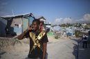 In this April 24, 2013 photo, Darlin Lexima speaks on the phone as he walks through Camp Acra in Port-au-Prince, Haiti. Lexima, 21, who lives in the camp for people displaced by the 2010 earthquake, was arrested by police early April 15 when he was walking home from a disco club as police were responding to residents protesting an earlier raid by an unidentified band of motorcyclist who set fire to their homes. In the few weeks since the mid-April confrontation, it has become an instant symbol for what many say is the growing use of threats and sometimes outright violence to clear out sprawling displaced person camps, where some 320,000 people still live. (AP Photo/Dieu Nalio Chery)