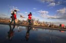 Red Cross volunteers walk past the remaining foundations of homes destroyed by the storm surge of superstorm Sandy in the Staten Island borough neighborhood of Oakwood in New York