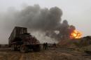 Fiirefighters put out a fire at oil wells, which were set ablaze by Islamic State militants before they fled the oil-producing region of Qayyara, Iraq
