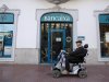In this photo taken Oct 23, 2012, a disabled man passes a Bancaixa regional savings bank that is now part of Spanish banking giant Bankia in La Vall D'Uixo, near Valencia, Spain. Thousands of townspeople and nearly a million across Spain followed bank manager's advice and invested their life savings in the bank's stocks. Lured by the family-like ties nurtured between bankers and customers, they poured their life's savings into higher-yielding financial instruments recommended by the people managing their money. When boom turned to catastrophic bust, they found the stock they had acquired had become all but worthless. (AP Photo/Alberto Saiz)