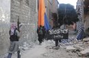 Free Syrian Army members accompained by fighters from the Islamist Syrian rebel group Jabhat al-Nusra carry their weapons as one of them holds al-Nusra's flag while walking in the old city of Homs