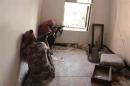 Free Syrian Army fighters take position as they aim their weapons inside a room in Bab Antakya district in Old Aleppo