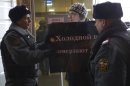 A protester argues with police officers outside the Federation Council on Wednesday, Dec. 26, 2012. Several protesters were detained Wednesday morning outside the upper chamber of Russia's parliament as it prepared to vote on a controversial measure banning Americans from adopting Russian children. The poster held by the protester reads: 