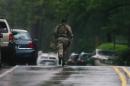 A member of the Pennsylvania State Trooper's Tactical Response Unit, runs along Route 402 on Saturday, Sept. 13, 2014, near the scene where a Pennsylvania State Trooper was killed and another trooper was injured during a shooting Friday night at the Pennsylvania State Police barracks in Blooming Grove Township, Pa. (AP Photo/The Scranton Times-Tribune, Butch Comegys)