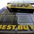 A building is reflected in the glass of a Best Buy store in New York