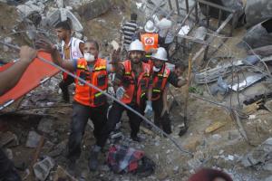 Rescue workers remove a body from the rubble of their &hellip;