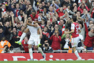 Robin van Persie, del Arsenal a la izquierda, carga a su compañero Theo Walcott, tras anotar un gol ante Sunderland en el partido de la Liga Premier inglesa, el domingo 16 de octubre de 2011. (AP Foto/Tom Hevezi)