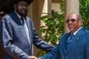 Sudan's President Omar al-Bashir (R) shakes hands with his host, South Sudan's President Salva Kiir, at Juba Airport