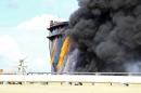 Black smoke billows out of a storage oil tank in the port of Es Sider in Ras Lanuf
