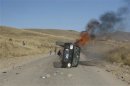 A car is seen in flames during a protest in Espinar