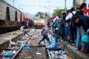 Migrants arrive at a Macedonian railway station in Gevgelija on August 22, 2015, after more than 1,500 mostly Syrian refugees entered Macedonia from Greece