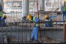 Migrant labourers work on a construction site on October 3, 2013 in Doha