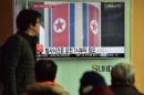 People watch a news report on North Korea's planned rocket launch as the TV shows file footage of North Korea's Unha-3 rocket which launched in 2012, at a railway station in Seoul on February 3, 2016