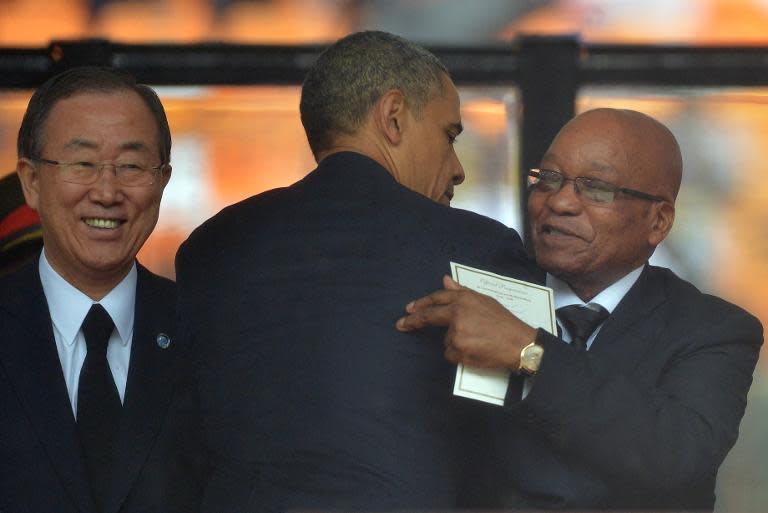 US President Barack Obama (C) is greeted by South Africa&#39;s President Jacob Zuma (R) next to UN Secretary General Ban Ki-moon at the memorial service for President Nelson Mandela at Soccer City Stadium in Johannesburg on December 10, 2013
