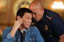 Philippine National Police chief General Ronald Dela Rosa whispers to President Rodrigo Duterte during the announcement of the disbandment of police operations against illegal drugs at the Malacanang palace in Manila