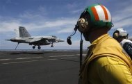 A U.S. Navy F/A 18 Hornet aircraft prepares its tailhook to catch an arresting wire in a landing maneuver during a tour of the USS Nimitz aircraft carrier on patrol in the South China Sea May 23, 2013. REUTERS/Edgar Su