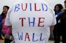 A man wears a hand-lettered "Build the Wall" t-shirt while waiting in line for a campaign rally with U.S. Republican presidential candidate Donald Trump in Portsmouth, New Hampshire